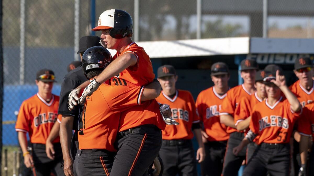 Huntington Beach High's Justin Brodt gets a hug from Nick Lopez after Brodt hit his second two-run home run in as many innings at Fountain Valley on Friday.