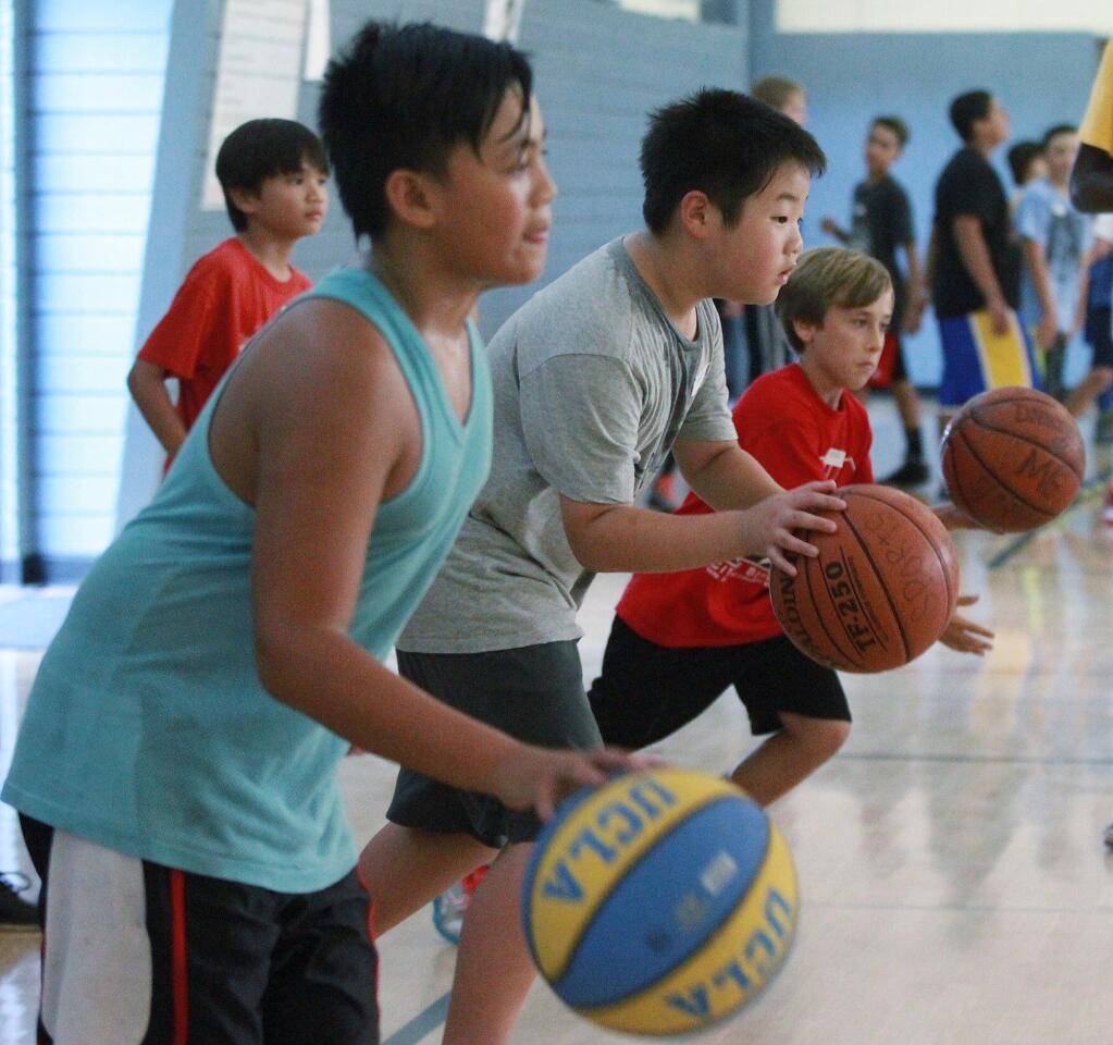 Jase Sadsad, 11, of Burbank, Jason Park, 11, of Tujunga, and Rocco Morse, 10, of Burbank, all take off for a basketball dribbling drill at the MVP Basketball Camp, coached by coordinator Mike Graceffo on the McCambridge Recreation Center basketball courts on Friday, July 25, 2014.