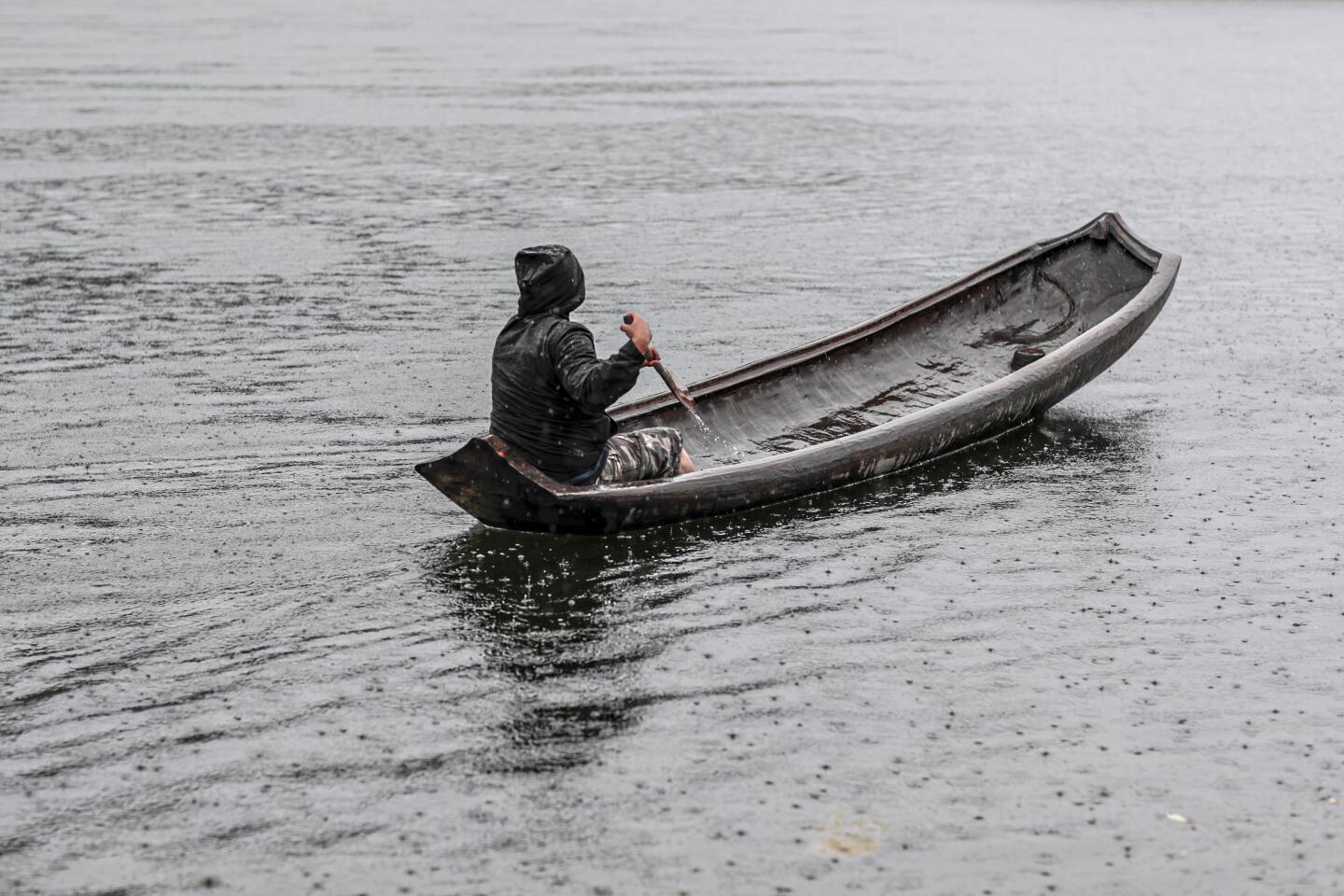 A guide paddles in the rain