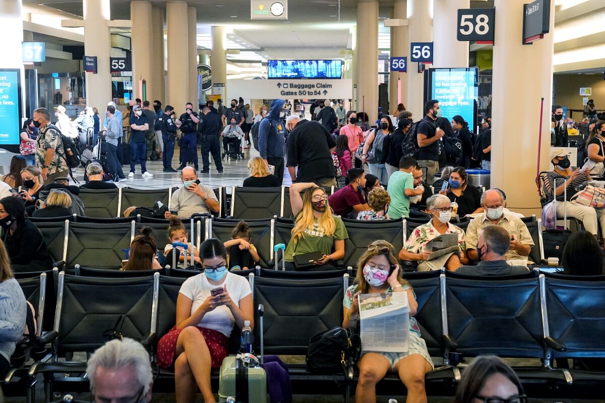 Travelers wait in a Los Angeles International Airport terminal in October