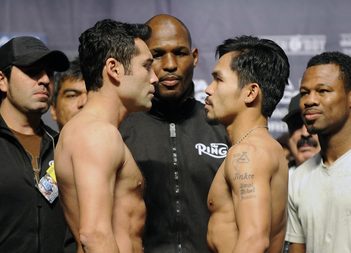 Oscar de la Hoya, left, and Manny Pacquiao square off during weigh-ins before their fight.