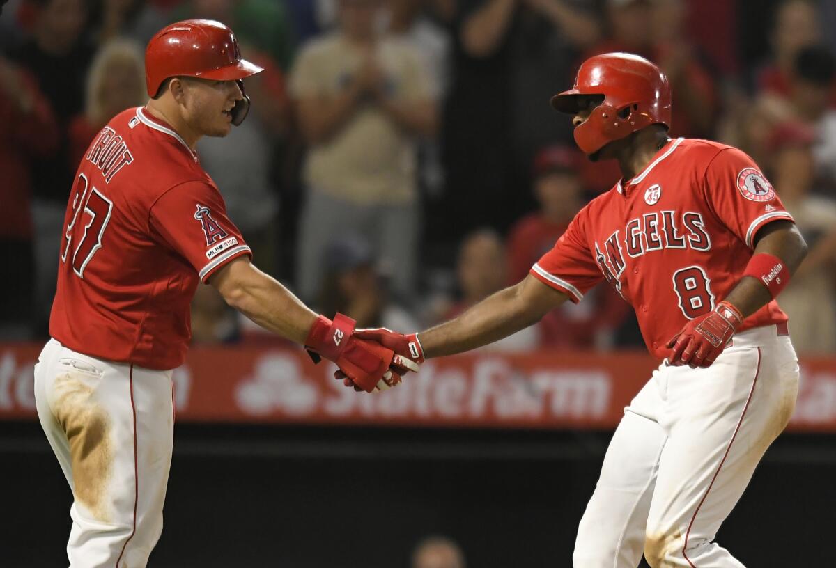Angels' Mike Trout, left, congratulates Justin Upton after he hit a three-run home run in the sixth inning against the Chicago White Sox at Angel Stadium on Thursday.