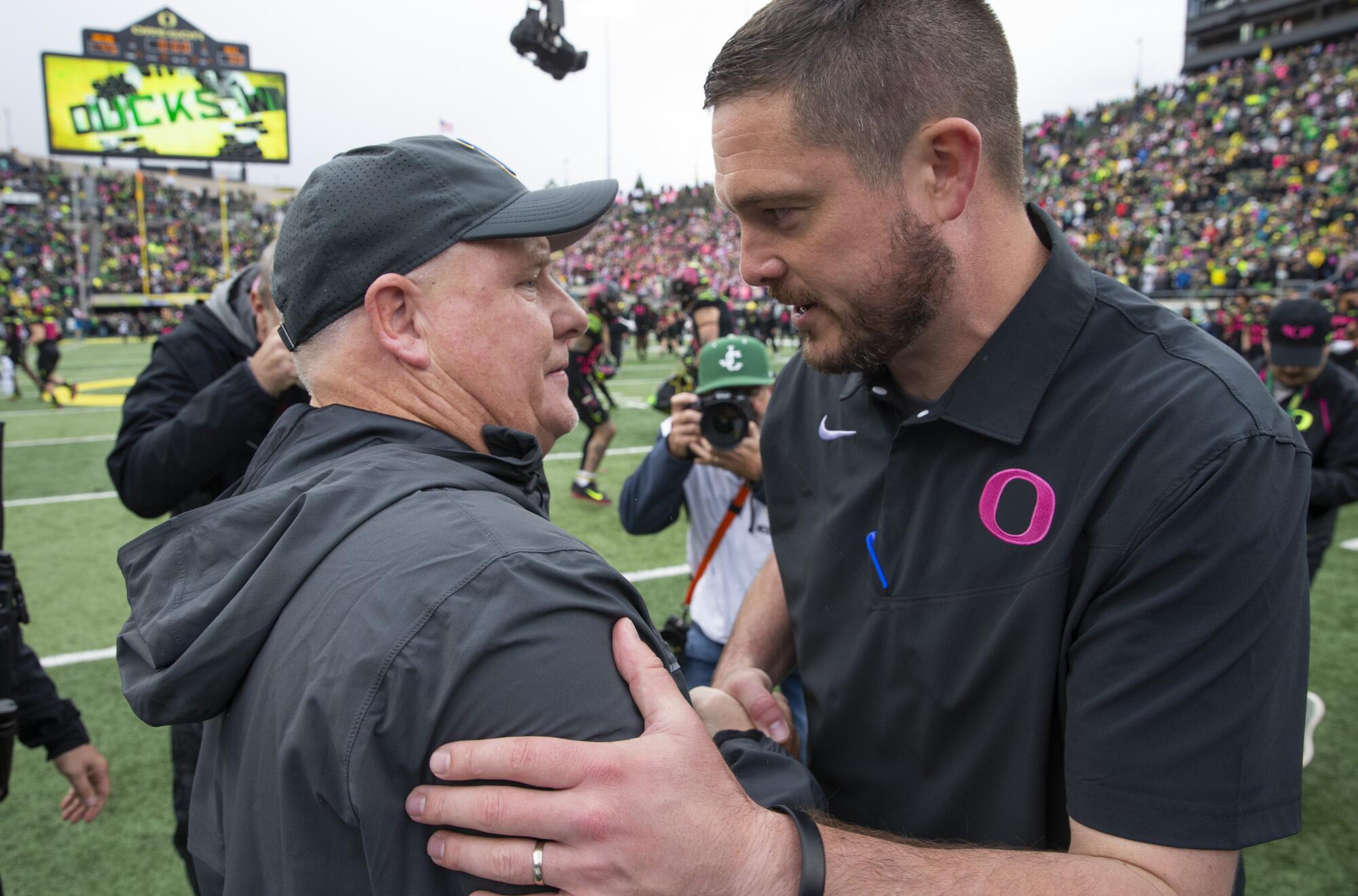 UCLA coach Chip Kelly and Oregon coach Dan Lanning meet at midfield.