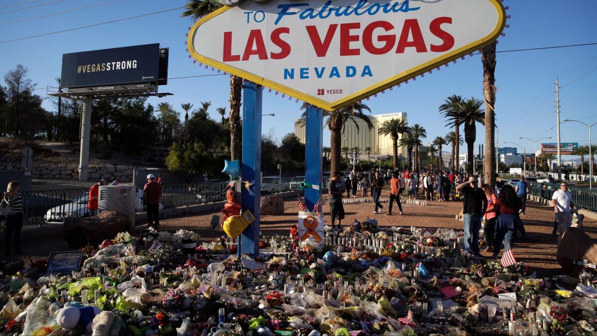 Flowers, candles and other items surround the famous Las Vegas sign at a makeshift memorial the day after the Oct. 1 mass shooting.