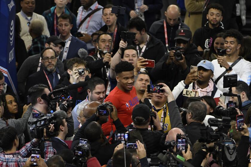 Milwaukee Bucks' Giannis Antetokounmpo, center, walks through the media during the NBA All-Star game media day, Saturday, Feb. 15, 2020, in Chicago. (AP Photo/David Banks)