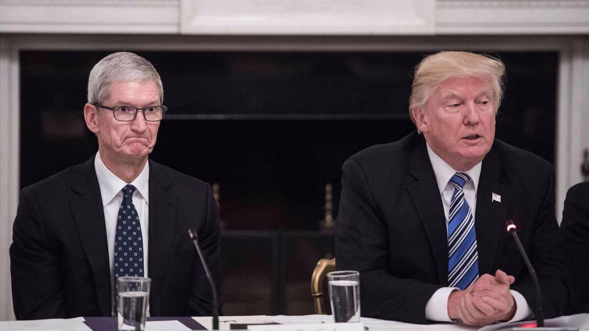 Apple CEO Tim Cook, left, was one of dozens of tech leaders who signed an open letter encouraging President Trump to continue DACA.