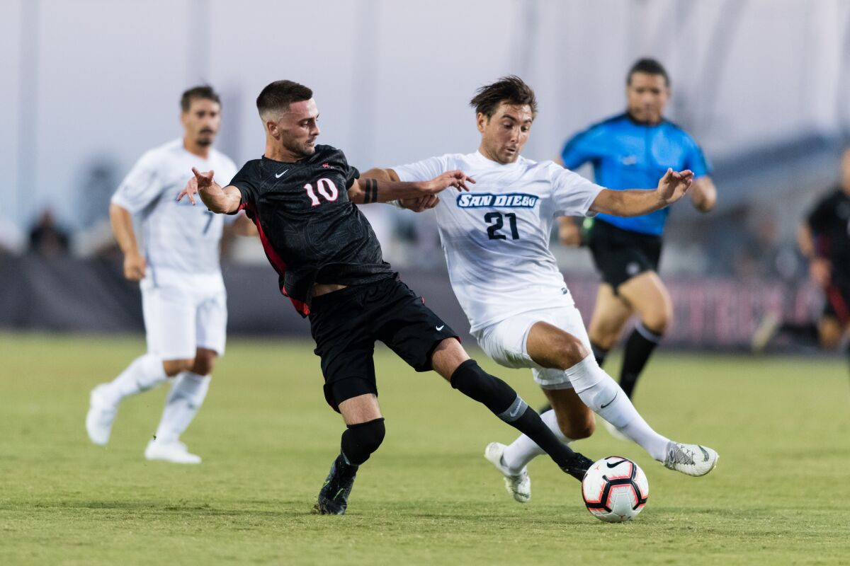 SDSU's Keegan Kelly tries to keep the ball from USD's George West in the Toreros' 3-2 win on the Sports Deck on Friday night.
