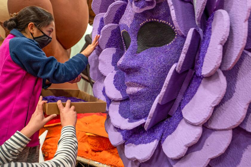 Emily Gonzales, 12, of San Gabriel is working on The Masked Singer float for the Rose Parade on Monday.