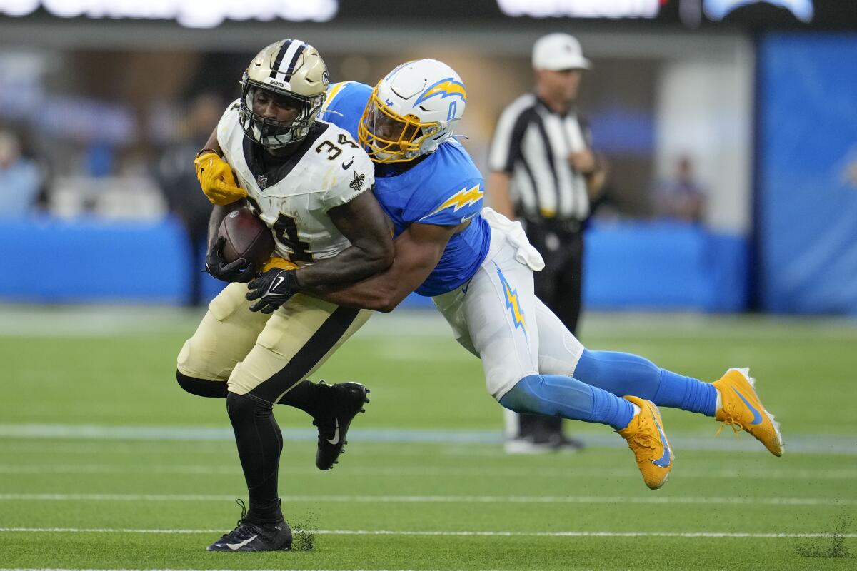 New Orleans Saints running back Darrel Williams is tackled by Chargers linebacker Daiyan Henley on Sunday.