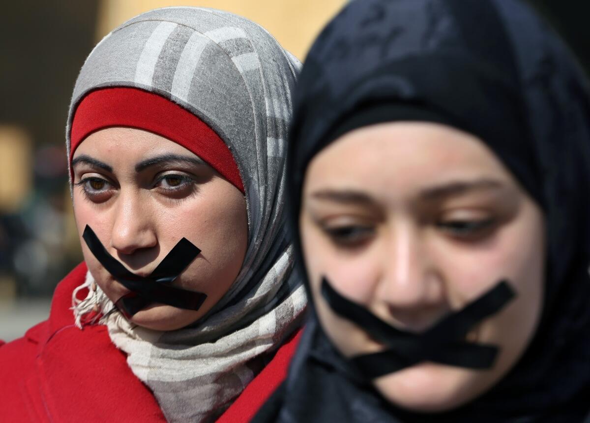 Lebanese journalists and activists tape their mouths at a rally in Beirut to show solidarity with journalists detained in Egypt.