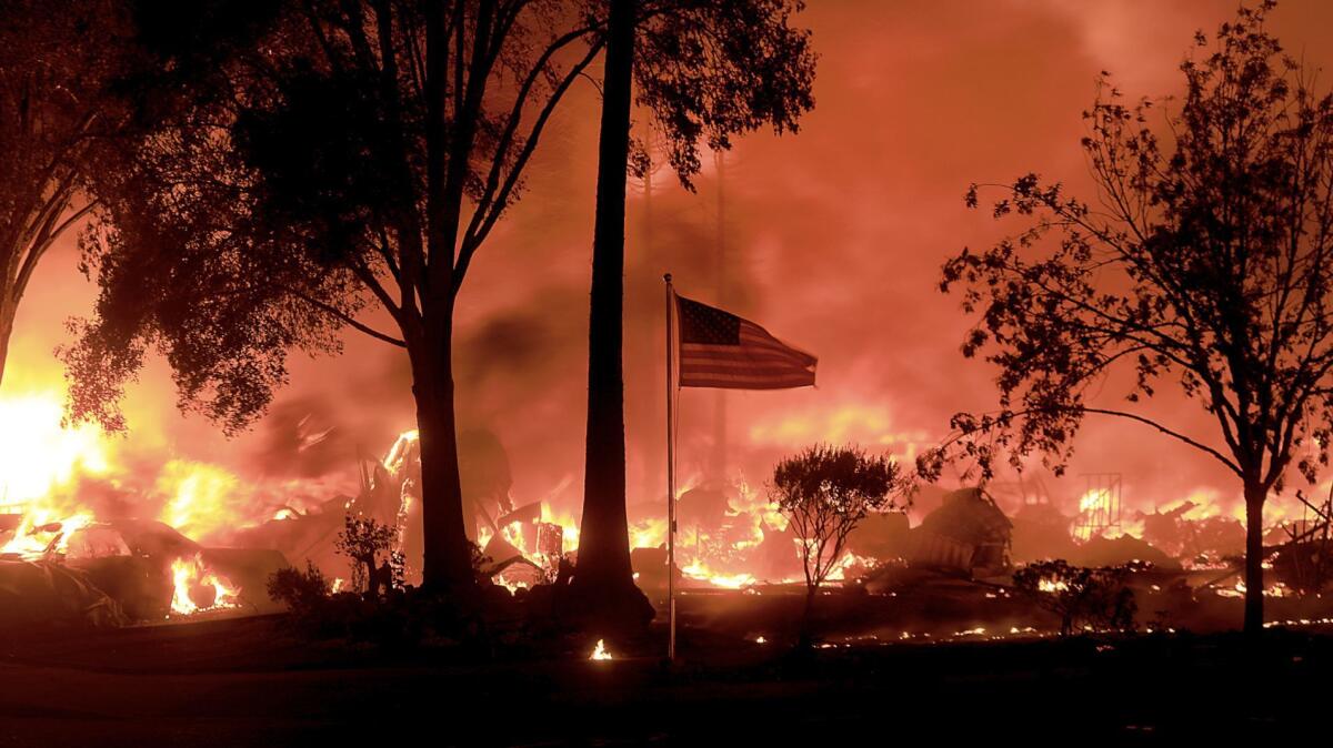 An American flag still flies as structures burn in Coffey Park in Santa Rosa.