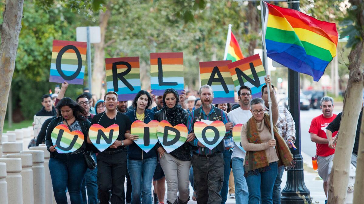 Several hundred supporters, led by Laura Kanter, at right, march to Sasscer Park after a vigil at Calle Cuatro Plaza in support of the Orlando shooting victims on June 12 in Santa Ana.