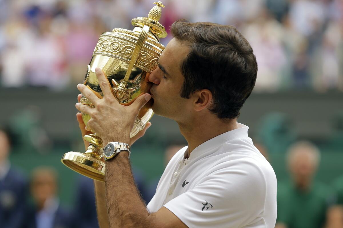 Roger Federer besa el trofeo de campeón de Wimbledon 