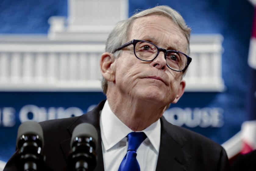 FILE - Ohio Gov. Mike DeWine pauses while speaking about the people of Dayton following the Dayton Mass Shooting on Tuesday, Aug. 6, 2019, at the Ohio Statehouse in Columbus, Ohio. DeWine has signed into law a gun rights bill eliminating an individual's duty to retreat before using force. The measure expands the so-called “stand your ground” right from an individual’s house and car to any place a person lawfully has the right to be. The Republican governor's decision followed months of saying any new gun legislation should include his proposals for for toughening background checks and boosting penalties for felons committing new crimes with guns. (Joshua A. Bickel /The Columbus Dispatch via AP, File)