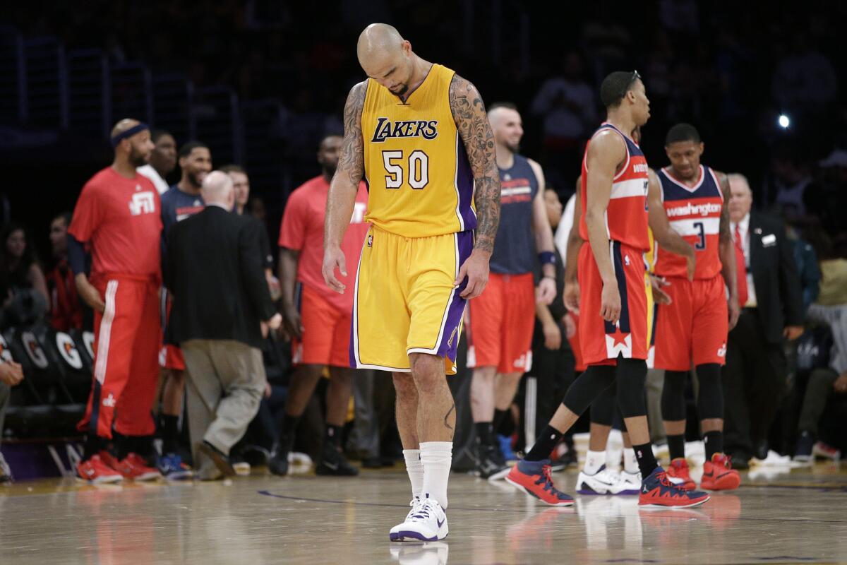 Dejected center Robert Sacre walks off the court after the Lakers blew a 19-point lead to the Wizards at Staples Center.