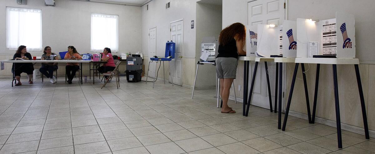Melissa Morales, right, votes at the Tenrikyo Mission in the Boyle Heights area of Los Angeles.