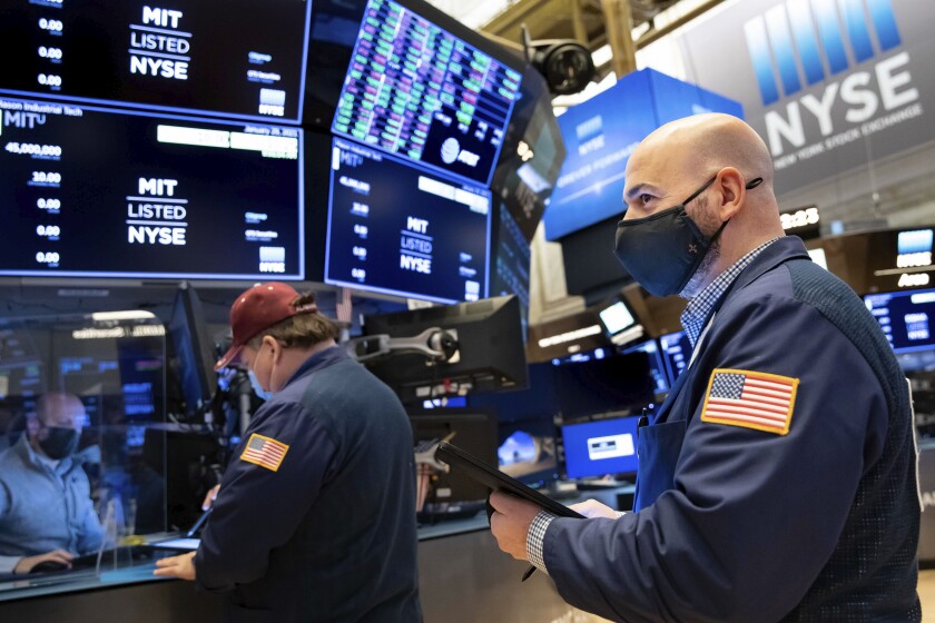 Trader Fred Demarco, right, works on the floor at the NYSE on Friday.