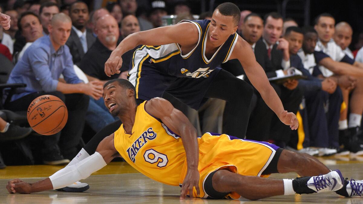 Lakers guard Ronnie Price, bottom, battles Utah Jazz guard Dante Exum for a loose ball during the first half of the Lakers' 98-91 exhibition win Sunday.