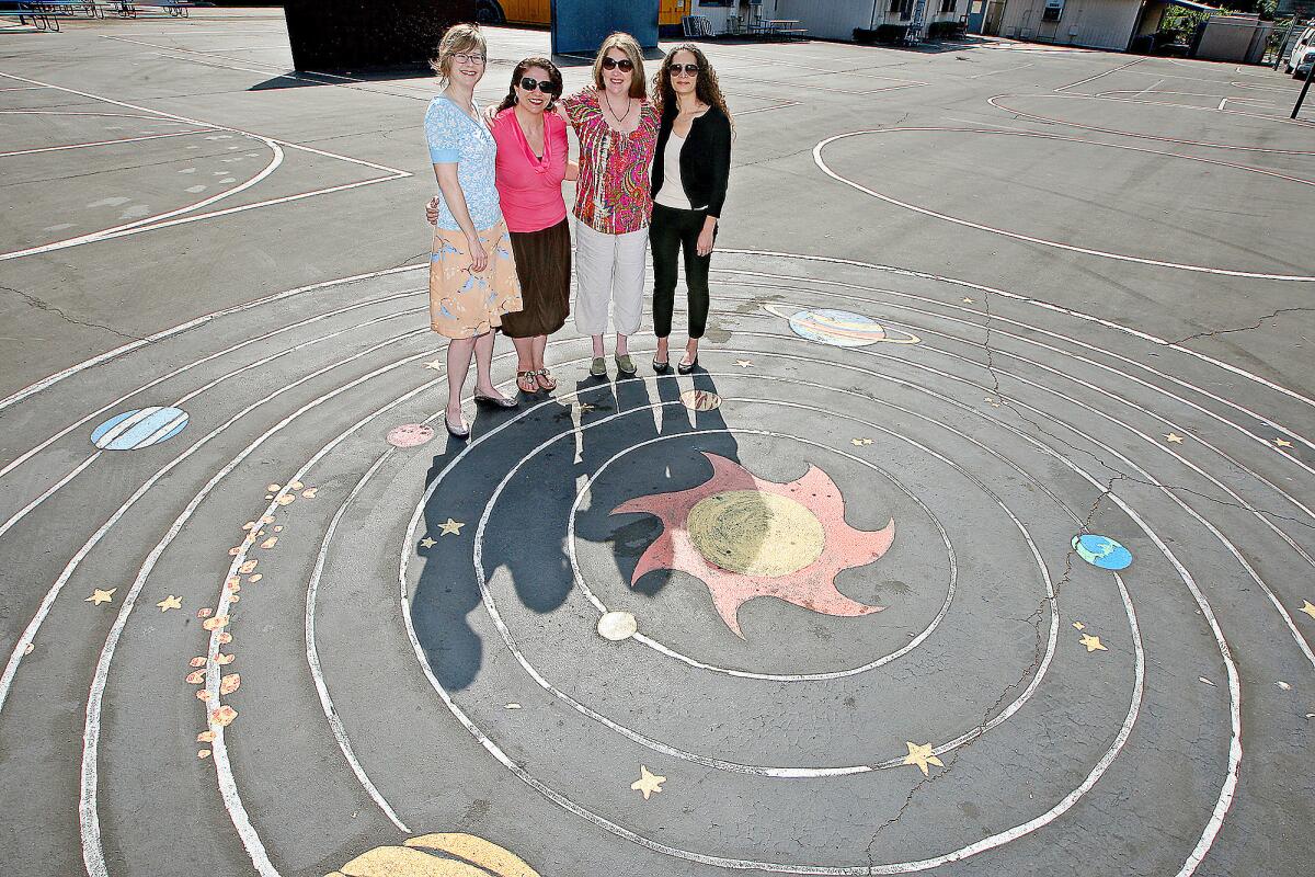 Rebecca Gray, principal Vickie Atikian, Gillian Bonacci and Hilary Stern stand on the Benjamin Franklin Elementary playground on Friday, June 6, 2014. Gray and Bonacci and Stern were some of the parents in the school's foundation who applied for and received state funds to replace the asphalt playground with greenery and permeable surfaces.