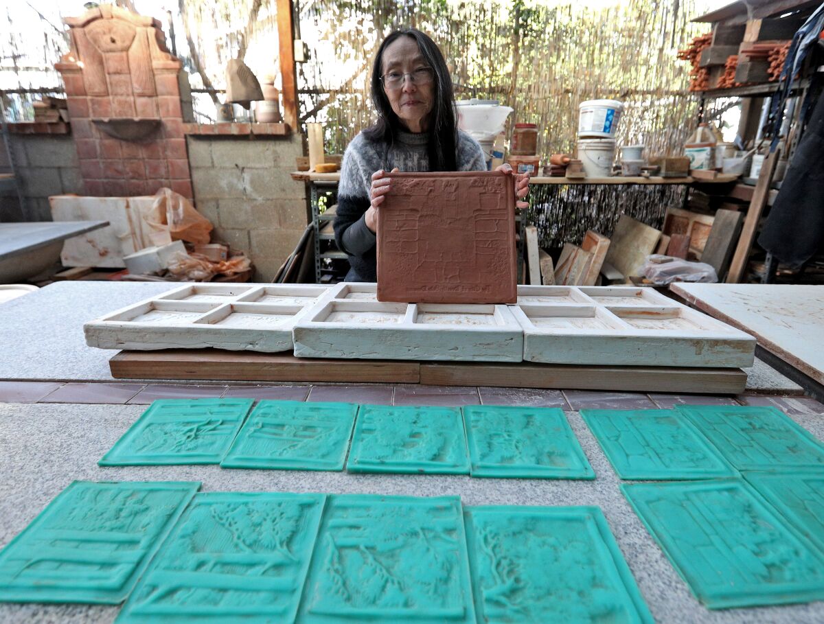 Pasadena tile artist Cha-Rie Tang shows a clay negative she made to recreate an Arts and Crafts-era tile fireplace made by Ernest Batchelder, which sits in a building owned by La Cañada Unified School District slated for demolition.