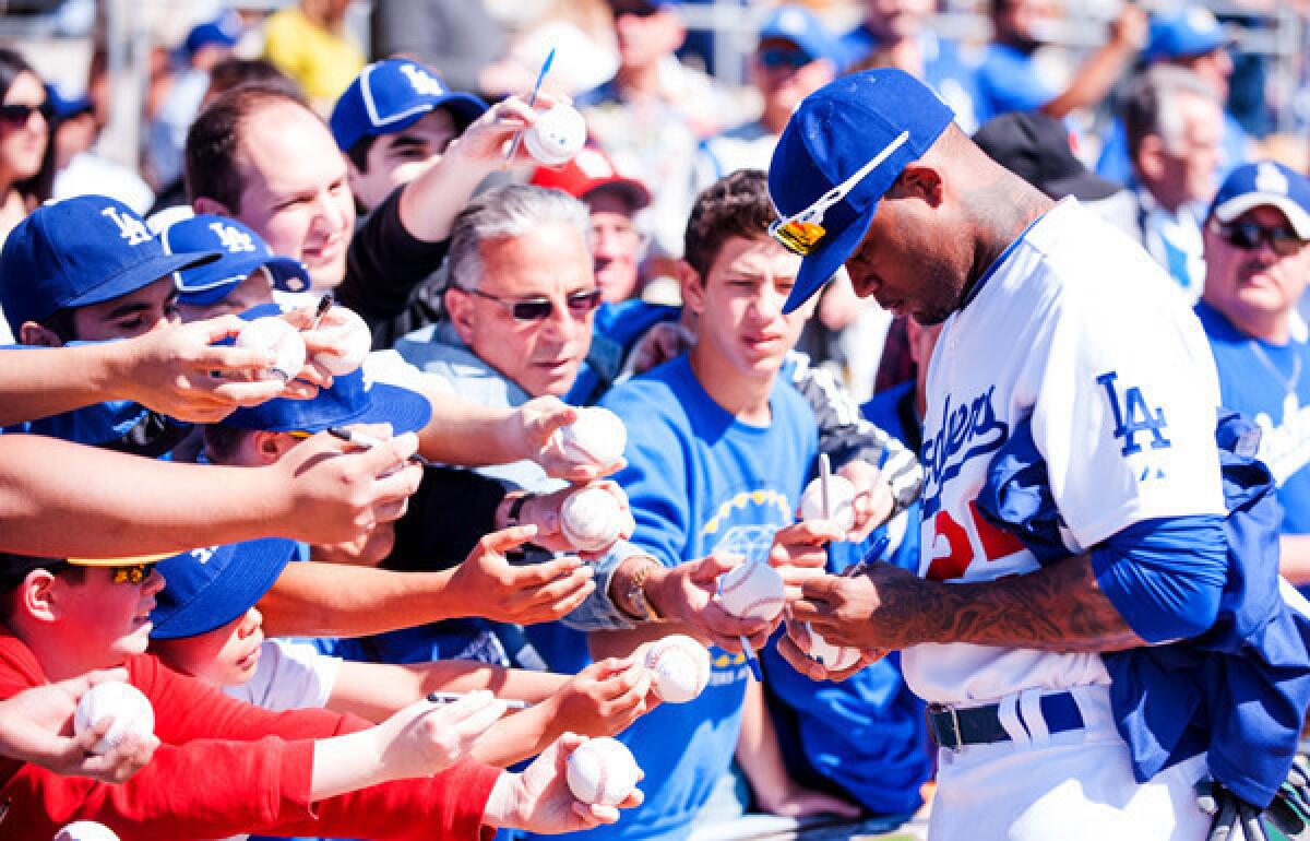 Dodgers outfielder Carl Crawford signs autographs before an exhibition game against the Chicago White Sox last month at Camelback Ranch.
