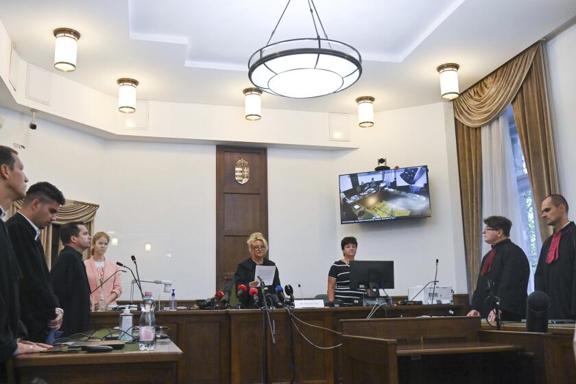 Judge Leona Nemeth, center, reads the verdict in the deadly collision of the Hableany sightseeing boat in Pest Central District Court in Budapest, Hungary, Tuesday, Sept. 26, 2023. The captain of a river cruise boat that collided with another vessel in Hungary’s capital in 2019, killing at least 27 mostly South Korean tourists has been found guilty of negligence and sentenced to five years in prison. A judge says the negligence of the Ukrainian captain, Yuriy Chaplinsky, had caused his river cruise boat, the Viking Sigyn, to collide with a tourist boat from behind, causing it to sink into the Danube River within seconds. (Noemi Bruzak/MTI via AP)
