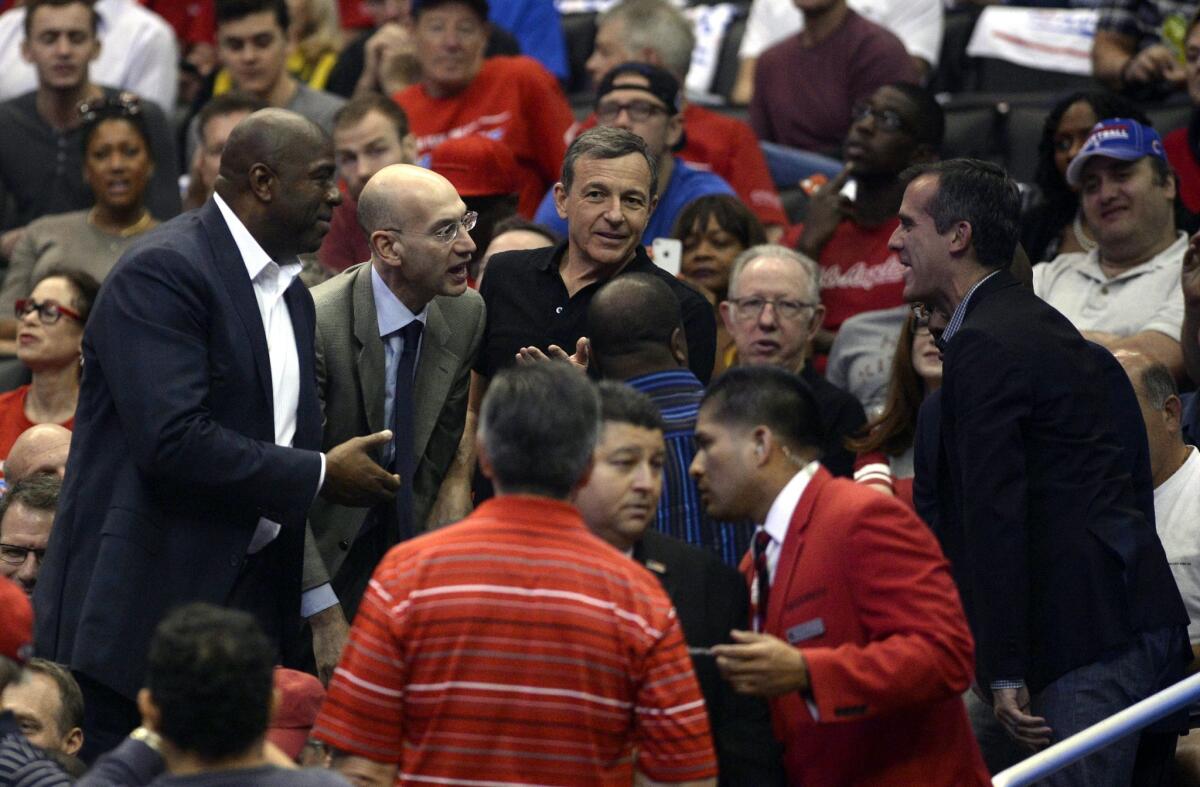 Magic Johnson, left, NBA Commissioner Adam Silver and Mayor Eric Garcetti, right, talk during a Clippers playoff game.
