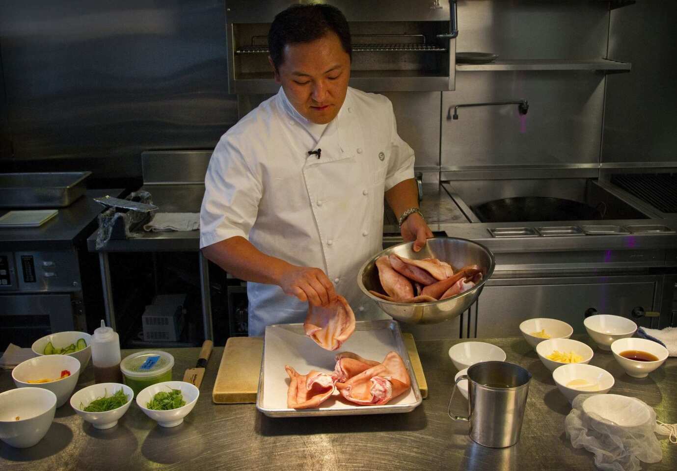 Chef Sang Yoon places pig ears on a platter surrounded by the other ingredients for the terrine.