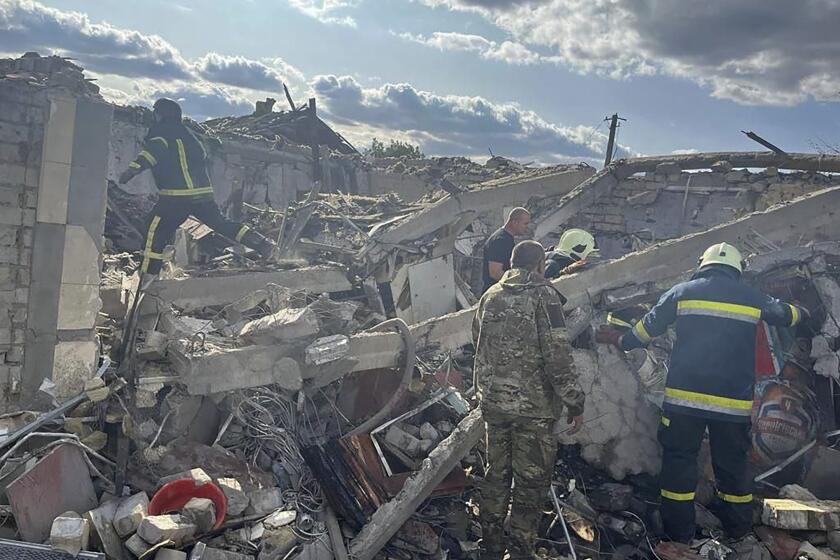 In this photo provided by the Ukrainian Presidential Press Office, emergency workers search the victims of a Russian rocket attack that killed at least 47 people in the village of Hroza near Kharkiv, Ukraine, Thursday, Oct. 5, 2023. (Ukrainian Presidential Press Office via AP)