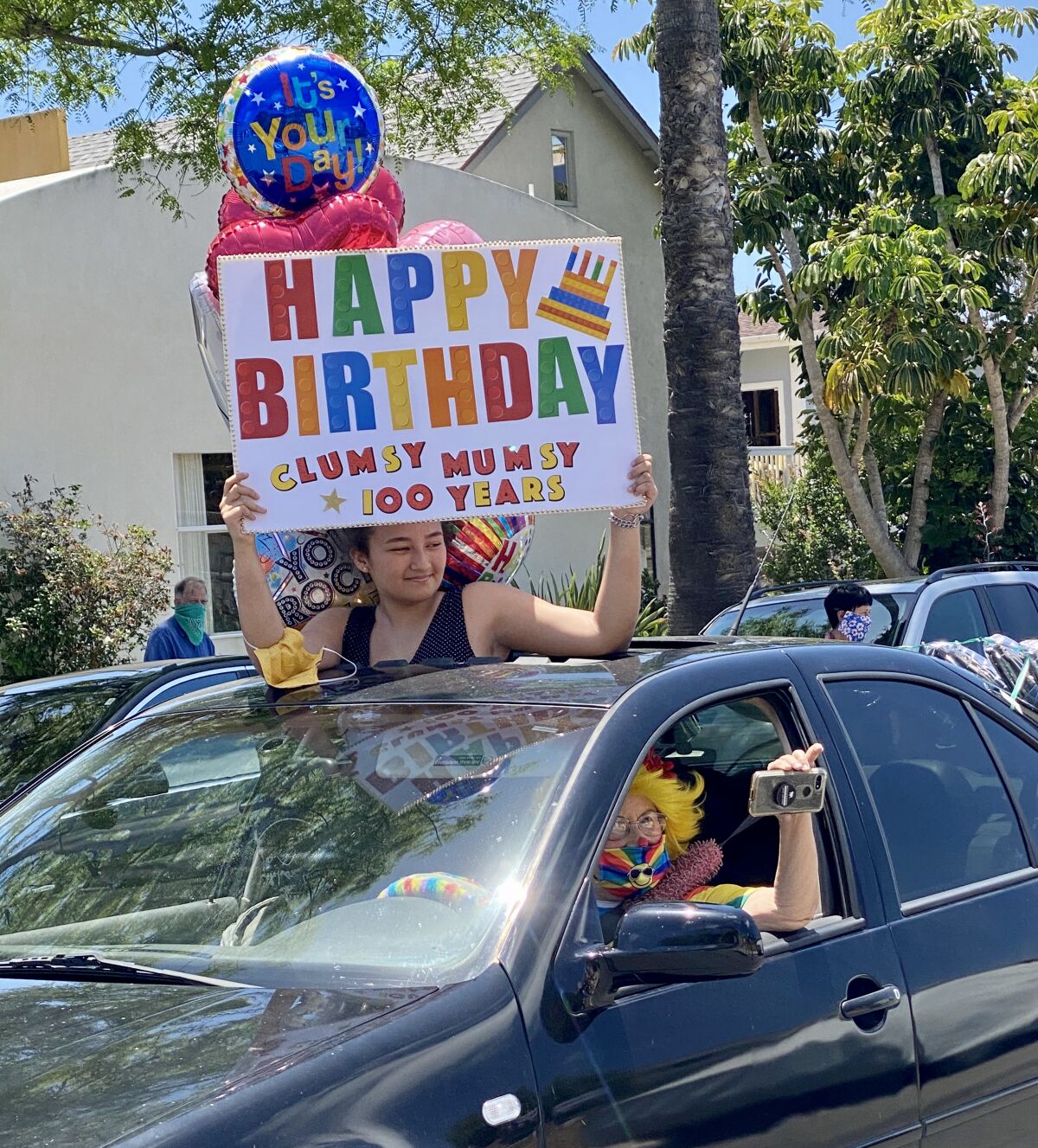 People in about 20 cars participated in Ruby Minder's 100th-birthday parade May 15, some greeting her by her clown name, Clumsy Mumsy.