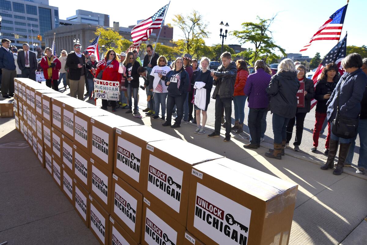 A group gathers around boxes filled with petition signatures collected by a group trying to repeal an emergency powers law.
