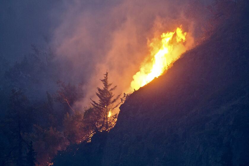 Flames are visible from the Beluga Point parking area near Anchorage, Alaska, on July 19, 2016, as a wildfire near McHugh Creek burns. A recent series of wildfires near Anchorage and the hottest day on record have sparked fears that a warming climate could soon mean serious, untenable blazes in urban areas — just like in the rest of the drought-plagued American West. (Marc Lester/Anchorage Daily News via AP)