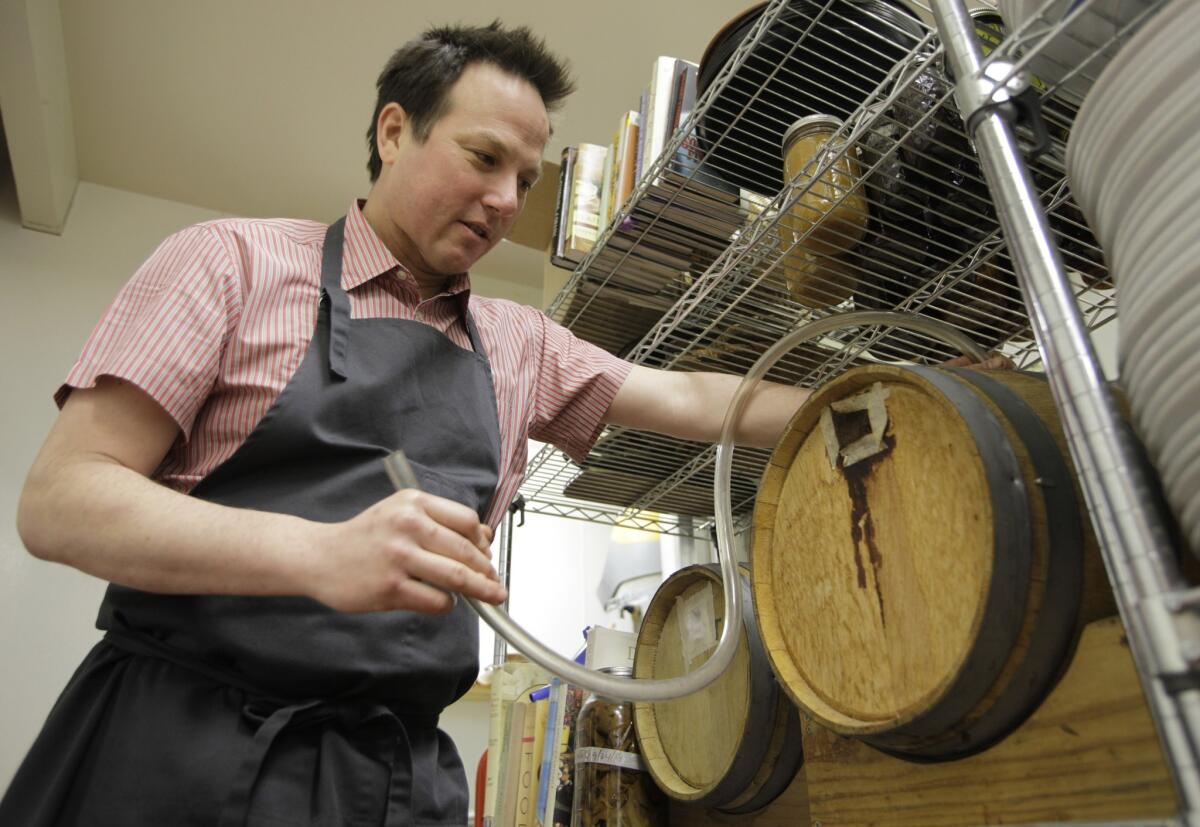 Chef Russell Moore with barrels of his red wine vinegar at Camino, his now-shuttered Oakland restaurant.