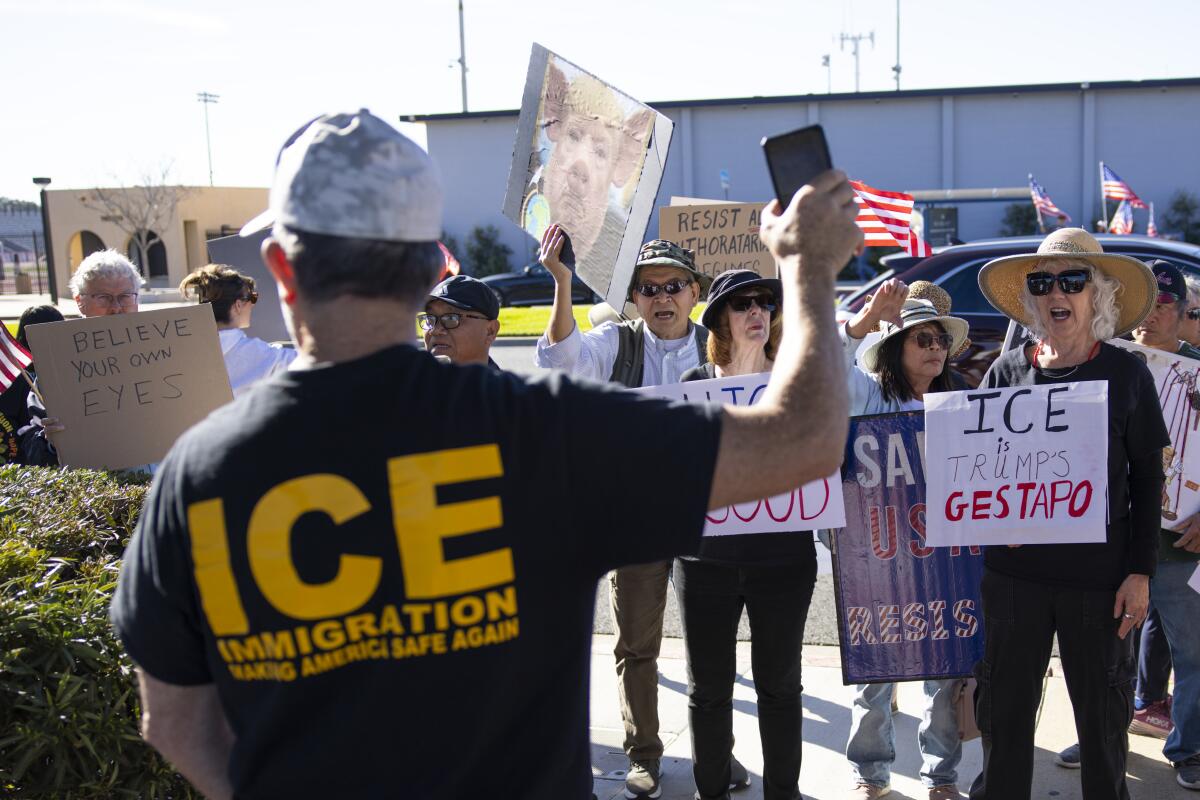 A man in an "ICE Immigration: Make America Safe Again" shirt stands across from protesters.