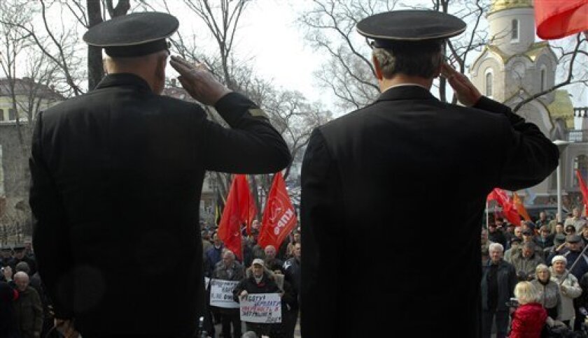 Retired Russian navy officers salute during a protest rally in Russia's main far-eastern port of Vladivostok, Russia, Saturday, April 11, 2009. About 300 protesters rallied Saturday in Vladivostok to protest the Kremlin's plan to radically streamline the nation's military. The rally has been organized by the regional Union of Officers, which mostly consists of military retirees. Its participants harshly criticized the planned military reform, which envisages a massive dismissal of military officers and a sweeping reduction of the number of military units. (AP Photo)