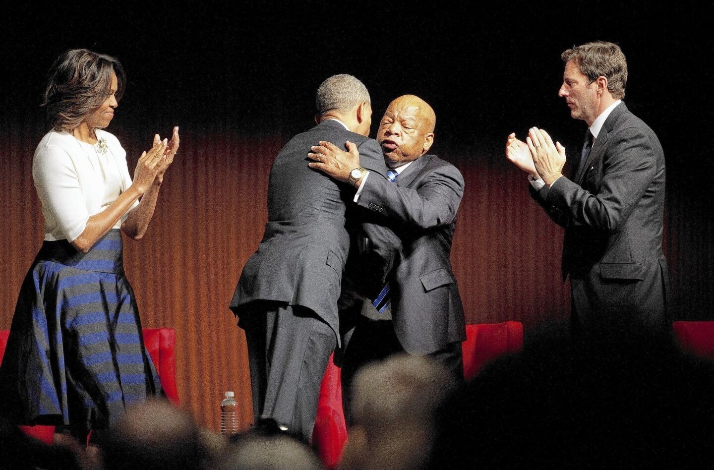 President Obama hugs Rep. John Lewis on stage at a civil rights event