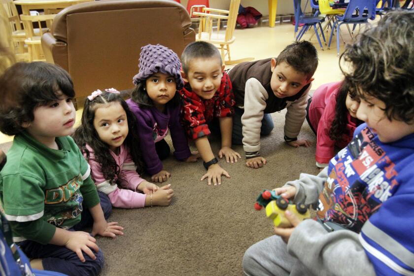 Pre-Schoolers in "toy sharing" learning exercise at Pacific Asian Consortium in Employment Early Childhood Education program in Los Angeles.