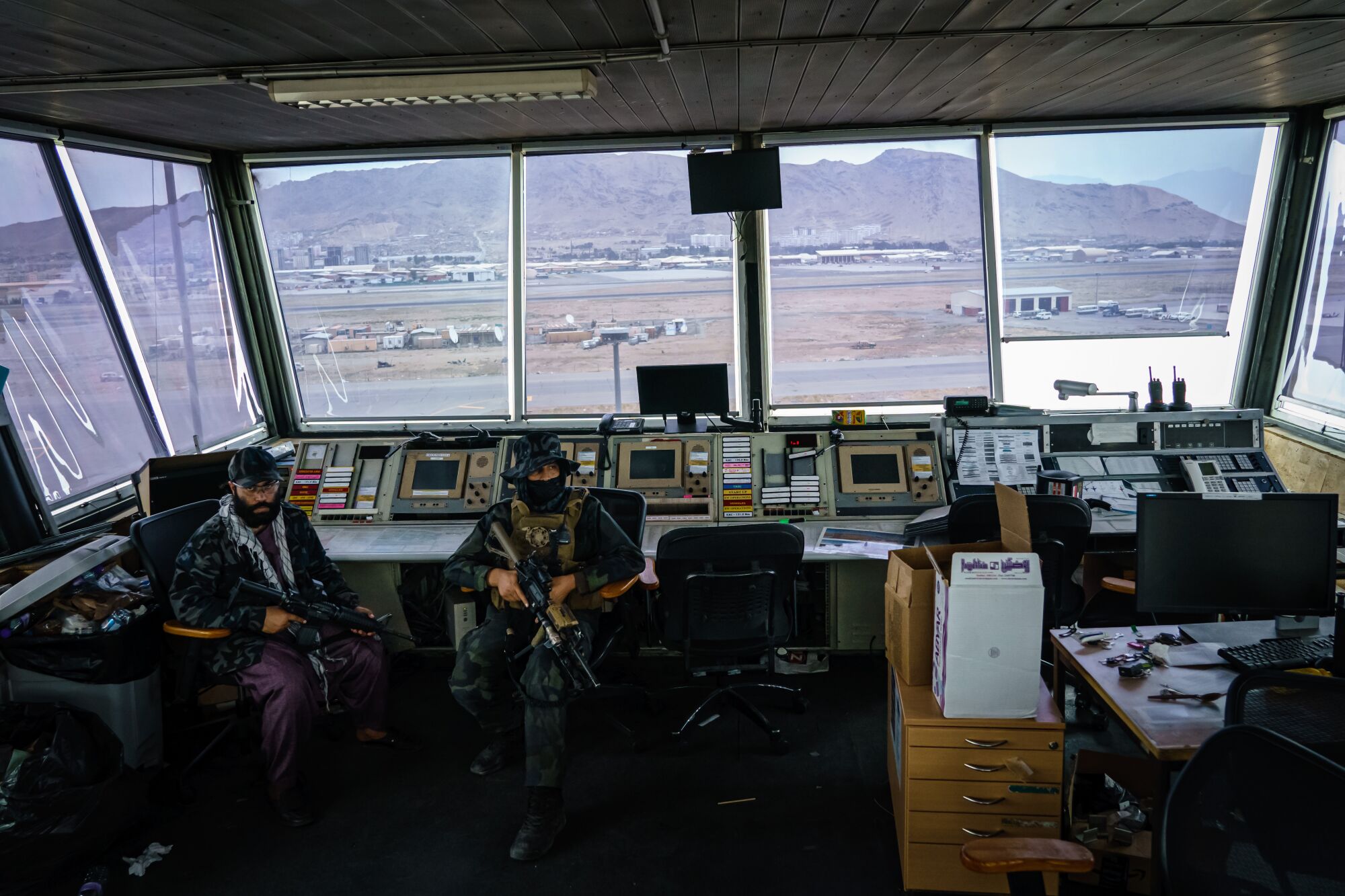 Taliban fighters sit at controller's stations in the Kabul airport's  control tower