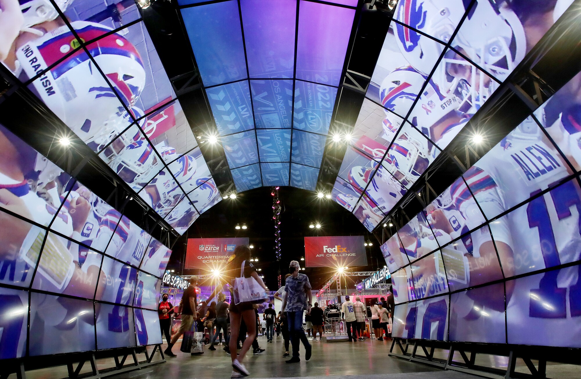 Photos: Super Bowl Experience opens at the L.A. Convention
Center 2 Fans walk though a tunnel of video monitors at the Super Bowl Experience.