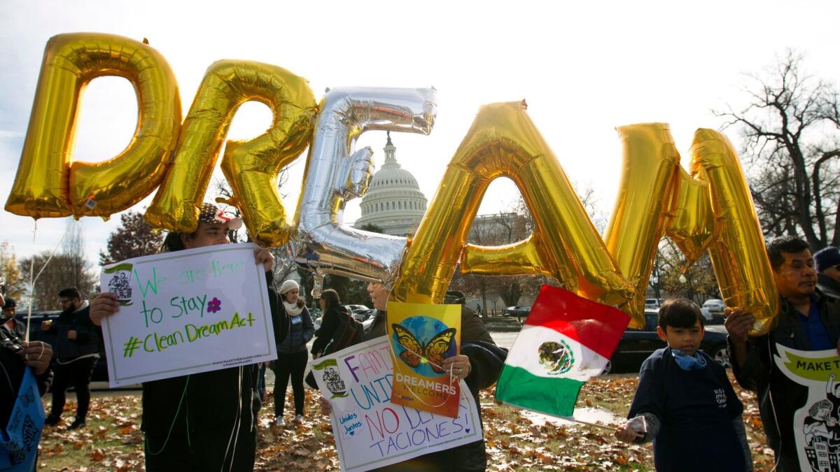 Demonstrators hold up signs in support of DACA on Dec. 6, 2017, in Washington.