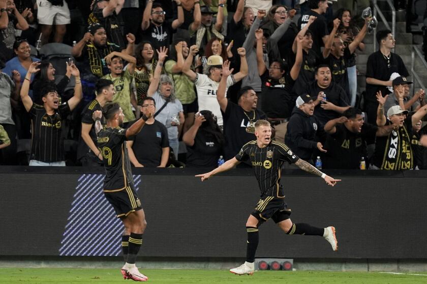 Los Angeles FC midfielder Mateusz Bogusz, right, reacts after scoring his side's game-tying goal with forward Denis Bouanga during the second half of a Leagues Cup soccer match against the Vancouver Whitecaps, Tuesday, July 30, 2024, in Los Angeles. (AP Photo/Ryan Sun)