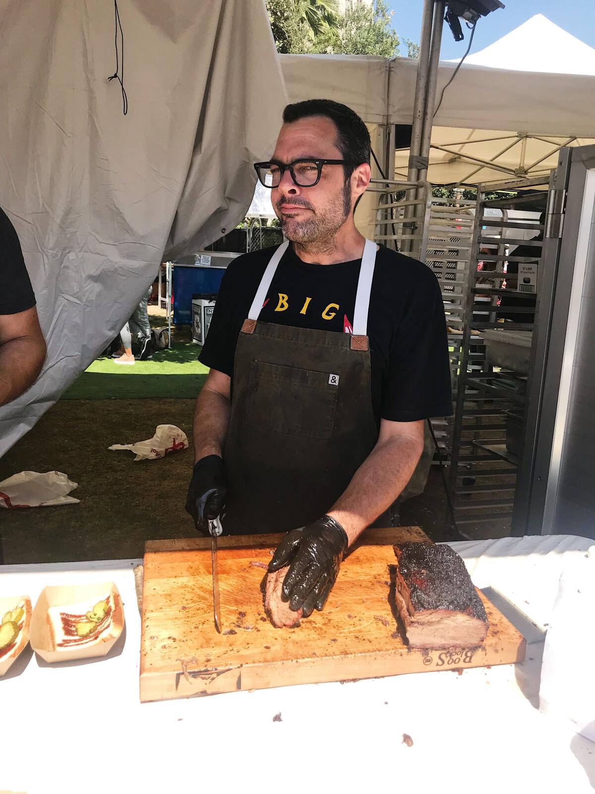 Barbecue master Aaron Franklin slicing brisket at the 2019 L.A. Times Food Bowl.