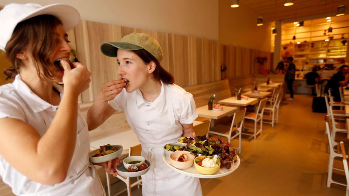 Sara Kramer, left, and Sarah Hymanson, chefs and co-owners of Kismet restaurant, sample some of their dishes.