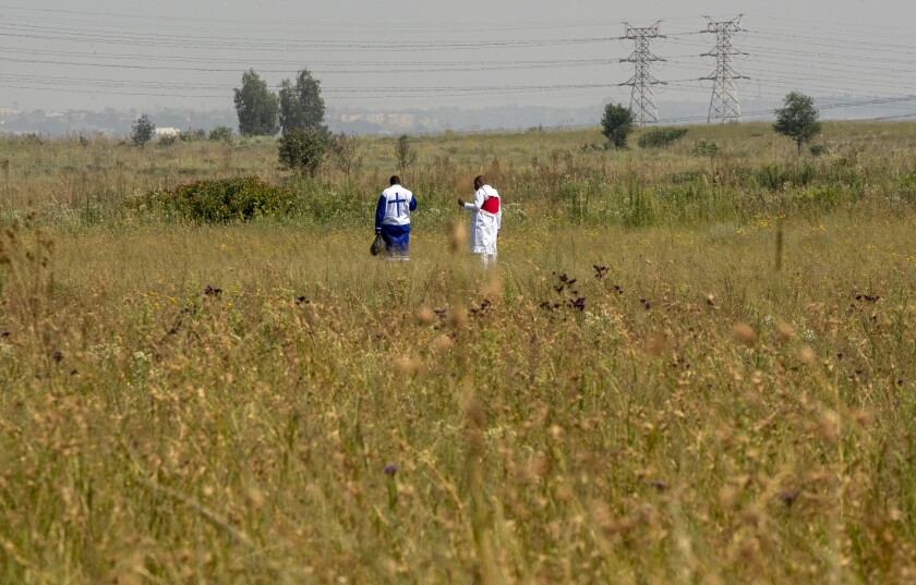 Worshipers pray in open fields, by the side of the road in Katlehong, east of Johannesburg, South Africa, Sunday, Jan. 17, 2021, as faith-based gatherings, are prohibited during the level 3 COVID-19 lockdown. (AP Photo/Themba Hadebe)