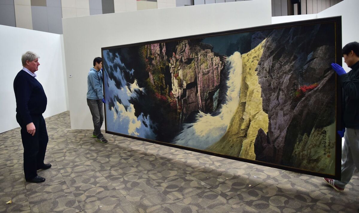 Dutch collector Frans Broersen inspects a painting that's part of "Hidden Treasures of North Korea Revealed," a show he's curating in Goyang, South Korea.