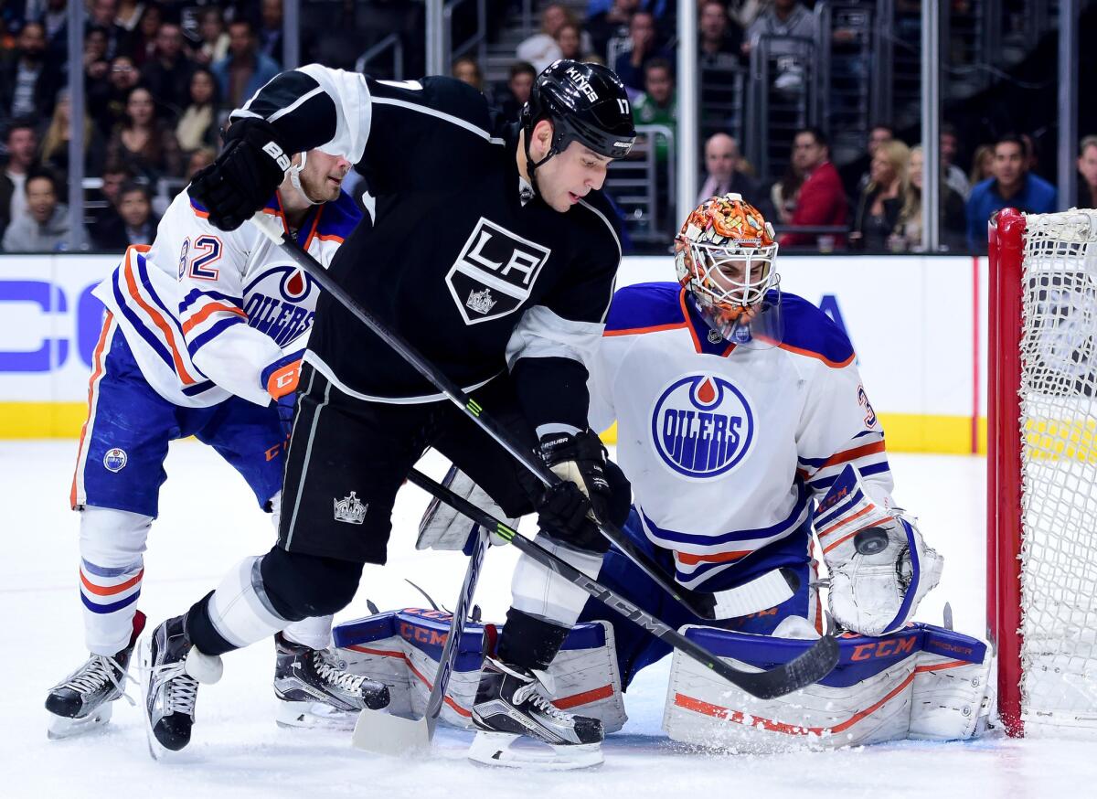 Kings forward Milan Lucic (17) plays a rebound in front of Oilers goalie Cam Talbot (33) and defenseman Jordan Oesterle (82) during the second period.