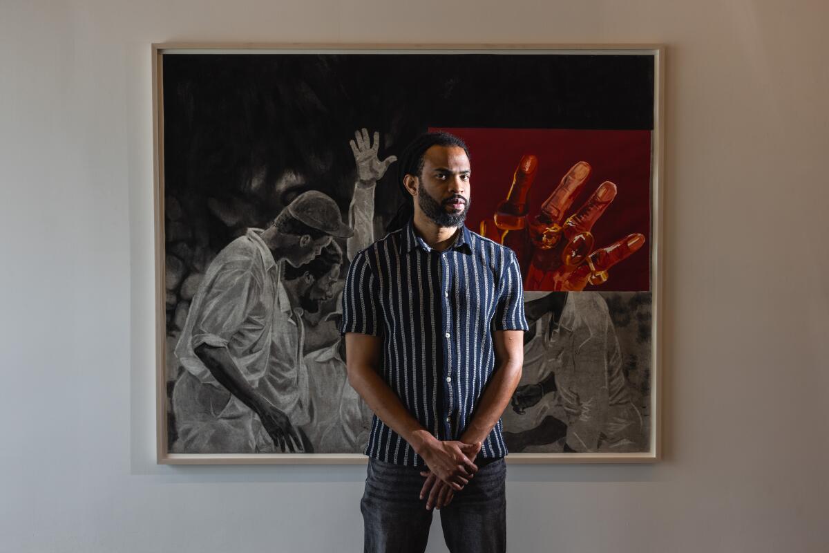 Jamaican-born artist Cosmo Whyte is photographed with one of his art pieces.
