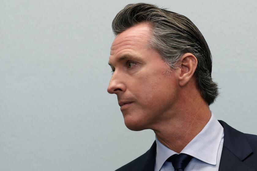 Governor-elect Gavin Newsom looks on during a news conference near the border Thursday, Nov. 29, 2018, in San Diego. Newsom was scheduled to meet with organizations aiding asylum seekers and to tour a nearby immigration detention center Thursday, before heading to Mexico City for the inauguration of Mexico's next president, Andres Manuel Lopez Obrador, this weekend. (AP Photo/Gregory Bull)