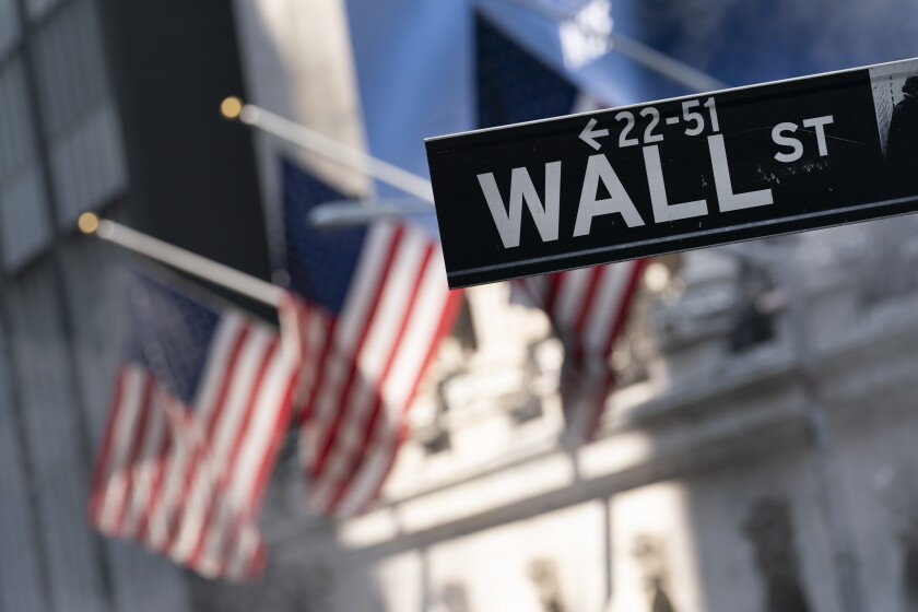A sign for Wall Street hangs in front of the New York Stock Exchange.