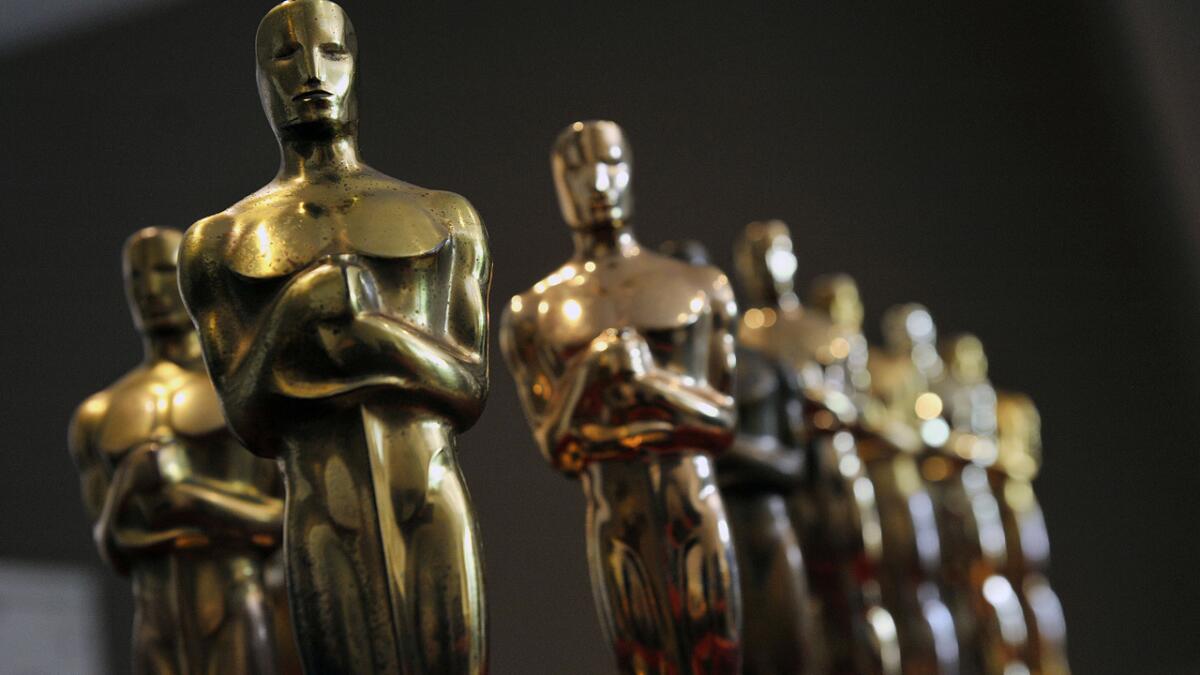 Nate Sanders displays the collection of Oscar statuettes that his auction company will sell online to the highest bidder.